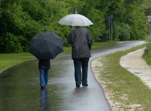 Twee mensen wandelen in de regen met paraplu
