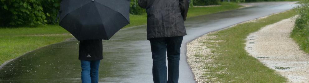 Twee mensen wandelen in de regen met paraplu