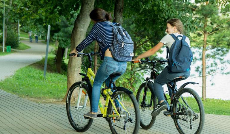 Twee fietsers op een fietspad in een park